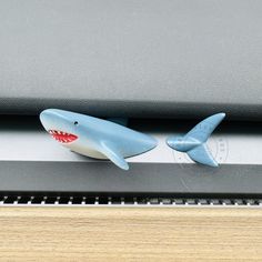 two plastic shark figurines sitting on top of a computer keyboard