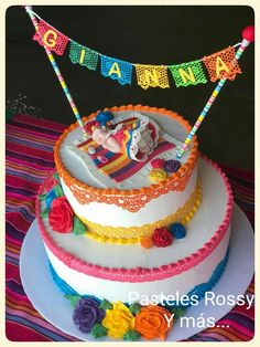 there is a birthday cake decorated with colorful decorations on the top and bottom tiers