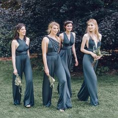 four beautiful women in long dresses posing for the camera