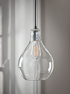 a clear glass light bulb hanging from a ceiling fixture in a room with white walls