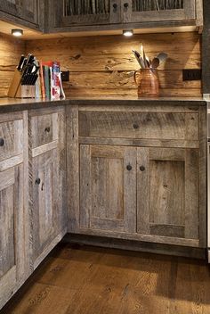 a kitchen with wooden cabinets and wood flooring, along with lights on the ceiling