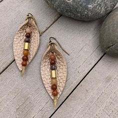 "Add a little boho flair to your day with genuine leather earrings. Champagne beige leather petal is accented with genuine Jasper and bronze glass bead on antique gold arrowhead pin. Lightweight earrings are perfect for everyday. - Earrings dangle just under 2\" on antique gold plated steel wires. - Handmade and ships from Florida" Bohemian Brown Leaf-shaped Earrings, Bohemian Leather Jewelry For Everyday, Bohemian Everyday Leather Jewelry, Bohemian Leather Drop Earrings, Beige Leather Jewelry, Bohemian Leather Dangle Earrings, Bohemian Leather Earrings, Bohemian Leather Teardrop Earrings, Bohemian Teardrop Leather Earrings