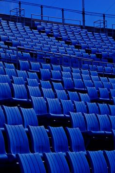 rows of blue seats in an empty stadium