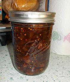 a glass jar filled with food sitting on top of a counter next to a bagel