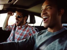 two men sitting in the back seat of a car