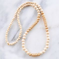 With a mix of whitewash and gold wood beads and in an easy pull-over-the-head style, this limited edition wood bead necklace is sure to dress up...well, anything! 8mm whitewashed and gold painted wooden beads gold-plated crimp with bead closure 28 inches long all Libby & Smee necklaces come packaged in a clear resealing bag for storage