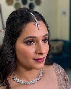 a woman wearing a necklace and tiara