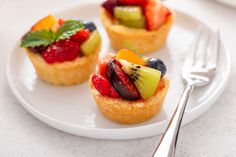 small fruit tarts on a white plate with silverware