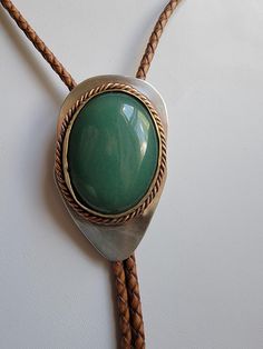 Green Onyx (Green Chalcedony), May's Birthstone, Cab set in Mixed metals in Bolo Tie or Lariat style neck piece. Created by Silversmith Glenay. Elegant Leather Lariat Jewelry, Formal Brown Concho Jewelry, Elegant Concho Bolo Tie, Formal Handmade Leather Jewelry, Southwestern Silver Leather Jewelry, Bolo Ties, Green Chalcedony, Bolo Tie, Neck Piece