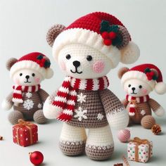 three teddy bears wearing knitted hats and scarves with presents scattered around them on a white surface