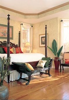 a bedroom with a four post bed and lots of furniture on the hardwood flooring