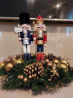 two nutcrackers are standing next to each other in front of christmas decorations