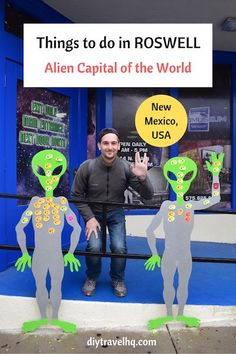 the man is standing next to two alien statues in front of a building with a sign that says things to do in roswell