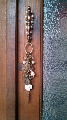 a wooden door with a bunch of charms hanging from it's handle and chain