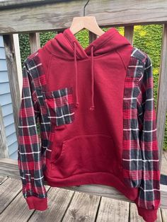 An upcycled sweatshirt with flannel sleeves. This one-of-a-kind sweatshirt is sure to turn a lot of heads and is perfect for the fall! Size: small machine wash normal, tumble dry Sweatshirt Flannel Upcycle, Flannel Sweatshirt Diy, Sweatshirt Makeover Diy, Flannel Crafts, Alter Clothing, Sweatshirt Makeovers, Upcycle Shirts, Sweatshirt Refashion Remake