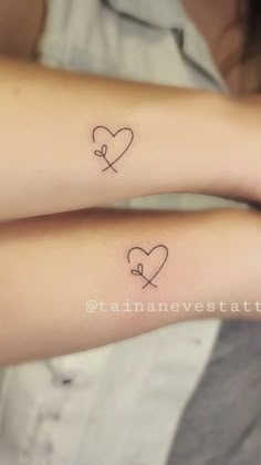 two small tattoos on both arms with hearts