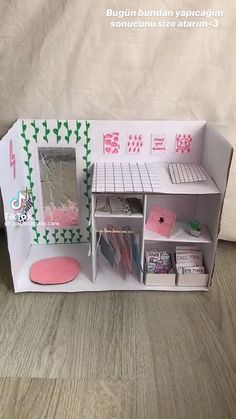 a doll house made out of cardboard with pink and green decorations on the front door