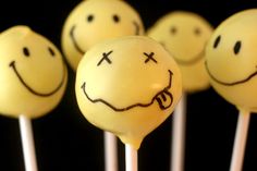 white cake pops with smiley faces drawn on them