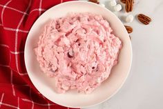 a white bowl filled with food on top of a red and white checkered table cloth