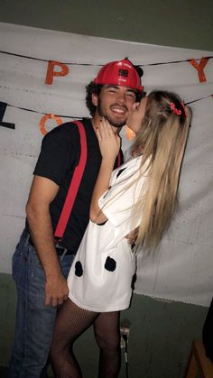 a man and woman kissing each other in front of a party banner that reads happy birthday