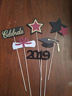 graduation cupcake toppers on sticks with ribbons and stars for the graduate's party