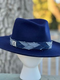 Designer choice!! Take a look at this fun denim blue adjustable hatband with different colors of denim that really make this hatband pop on any style/color of hat. The band is 22.5" x 1.25" and has adjustable navy-blue suede ties in the back so it can fit hats from 22.5-34". The band is secured by two gold tie clamps in the back to give it a nice, finished look. The hat band has been sewn together and treated with fray protector to help keep this hatband looking good for years to come. To comple Casual Adjustable Felt Hat For Country Events, Adjustable Casual Felt Hat With Flat Crown, Blue Short Brim Felt Hat For Fall, Trendy Blue Hat With Flat Brim, Trendy Adjustable Blue Fedora, Trendy Blue Brimmed Fedora, Denim Blue Hat With Curved Brim, Adjustable Navy Wide Brim Hat, Blue Country Hat With Short Brim