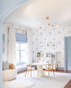 a living room filled with furniture and a white table in front of a blue door