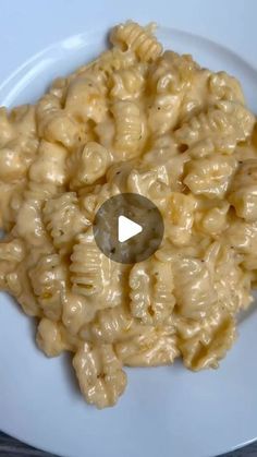 macaroni and cheese on a white plate with a small hole in the middle