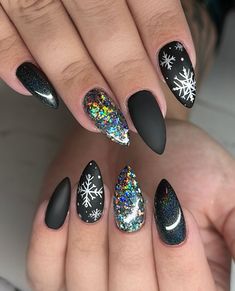 Bold matte black nails adorned with intricate white snowflakes and holographic glitter accents offer a striking, celestial winter vibe. The iridescent sparkles on two nails contrast beautifully against the matte and glossy finishes, creating a dazzling yet sophisticated look. This design feels perfect for both holiday parties and cozy winter evenings. Matte Winter Nails, Matte Black Nails, Winter Nail Designs, White Snowflake, Holographic Glitter, Cozy Winter, Black Nails, Elevate Your Style, Winter Nails