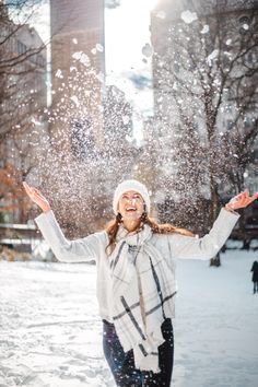 a woman is throwing snow in the air