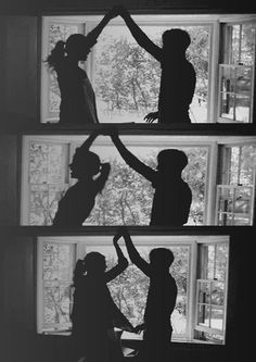 three silhouettes of people standing in front of a window with their hands up to each other