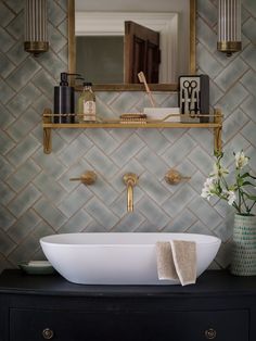 a bathroom sink sitting under a mirror next to a shelf