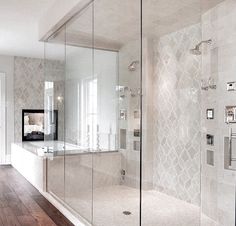 a bathroom with a walk in shower next to a wooden floor