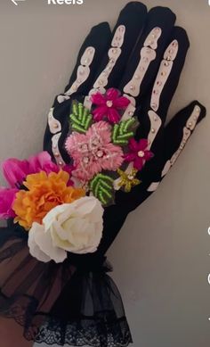 a glove with flowers on it is hanging from the wall