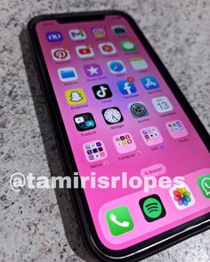 the iphone is pink and black with many different icons on its back side, as well as an image of someone's phone