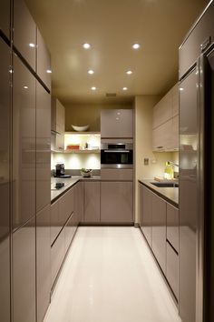 an empty kitchen with stainless steel appliances and white flooring is pictured in this image