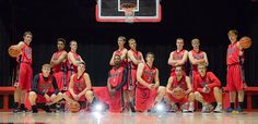 a group of young men standing next to each other in front of a basketball hoop