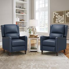 a living room with two blue chairs and a coffee table in front of a window