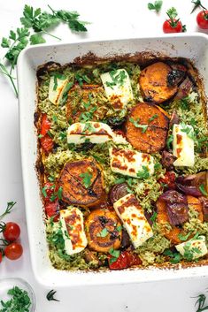 a casserole dish with vegetables and tofu in it on a white table