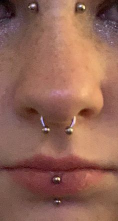 a woman with piercings on her nose and nose ring in front of her face