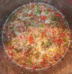 a pot filled with vegetables and sauce on top of a stove