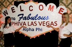 two women standing in front of a sign that says welcome to fabulous fahluous phiva las vegas