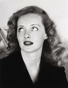 black and white photograph of a woman with her eyes wide open looking at the camera