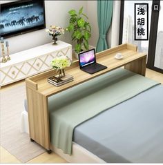 a bed with a laptop on top of it next to a dresser and tv stand