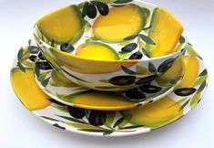 three bowls and two plates with lemons on them, one has black olives