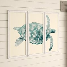 three blue and white sea turtle paintings hanging on the side of a wall in a room