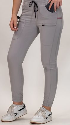 Chic and Functional Elevate your work attire with the Women’s Scrub Jogger Style 300 Pearl Gray. These joggers are a stylish staple for any healthcare professional, offering a sleek design that doesn’t compromise on functionality. The pearl gray hue is versatile, pairing well with a variety of scrub tops for a coordinated look. Premium comfort: Made from a durable blend of 71% polyester, 23% viscose, and 6% spandex, these joggers provide the ultimate comfort for those long shifts. The fabric is Scrubs Style, Jogger Scrubs, Scrubs For Women, Scrub Style, Pearl Gray, Mens Scrubs