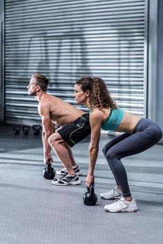 a man and woman doing push ups with kettles