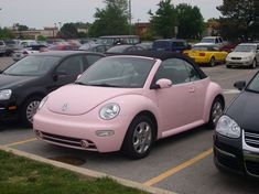 a pink car is parked in a parking lot