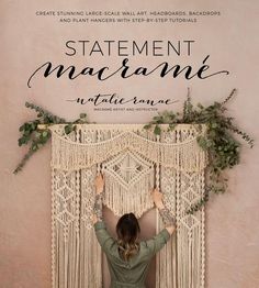 a woman standing in front of a macrame wall hanging